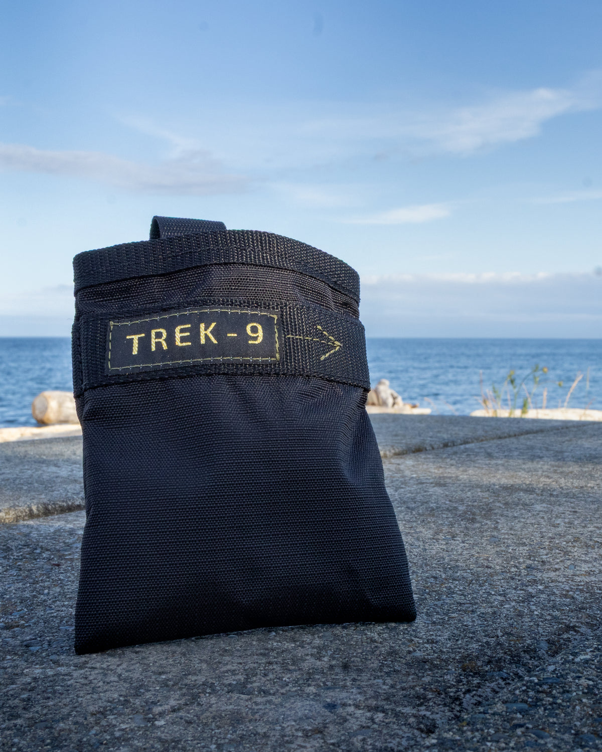Black Trek-9 dog treat pouch with reversible liner and magnetic closure. Made from high durability ripstop fabric for both the shell and the liner. Easy to wash, and dries quick. Has a belt loop for attaching to body or bag. 