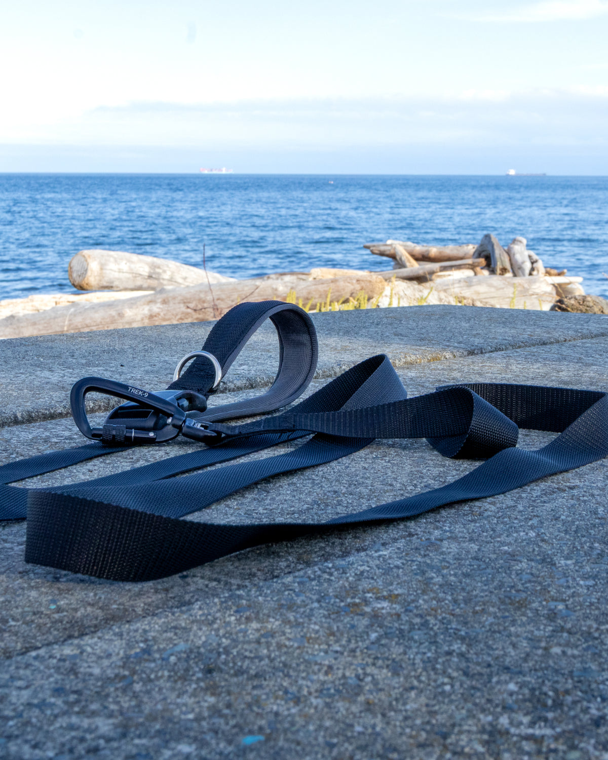 A black Trek-9 Dog leash with aluminum swivel carabiner, nickel plated d ring, air mesh padded handle, and rugged side release buckle, made from high quality nylon webbing